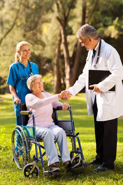 Arzt grüßt ältere Patientin — Stockfoto