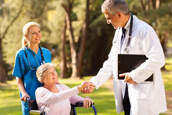 Médico handshaking médico com paciente sênior — Fotografia de Stock