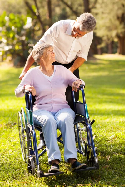 Figlio di mezza età che porta la madre disabile a fare una passeggiata — Foto Stock