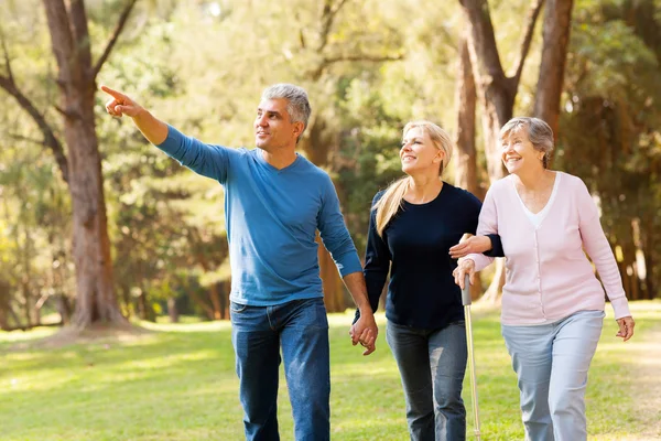 Middle aged couple taking elderly mother for a walk — Stock Photo, Image