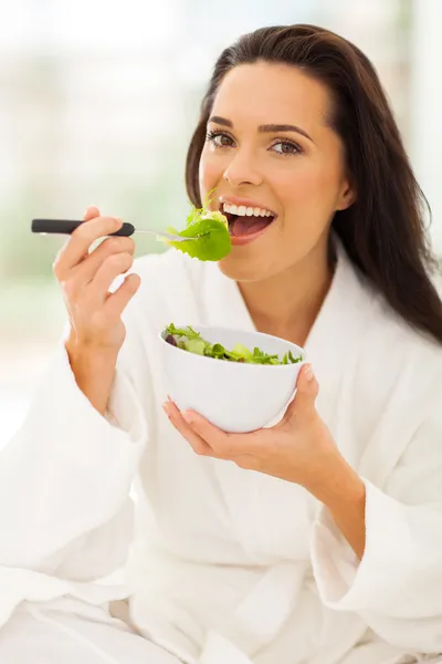 Mulher de roupão branco comendo salada — Fotografia de Stock