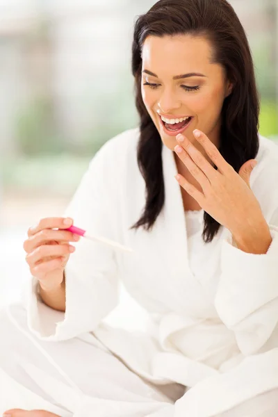 Mujer feliz mirando la prueba de embarazo positiva —  Fotos de Stock