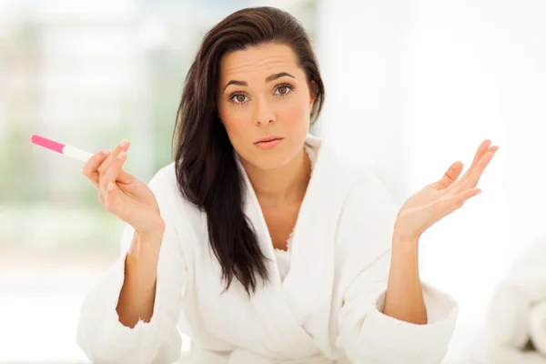 Sad young woman holding pregnancy test — Stock Photo, Image