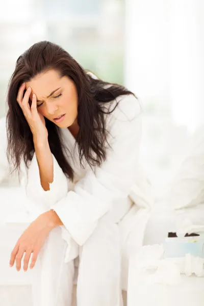 Yatakta oturmuş ve baş ağrısı olan kadın — Stok fotoğraf