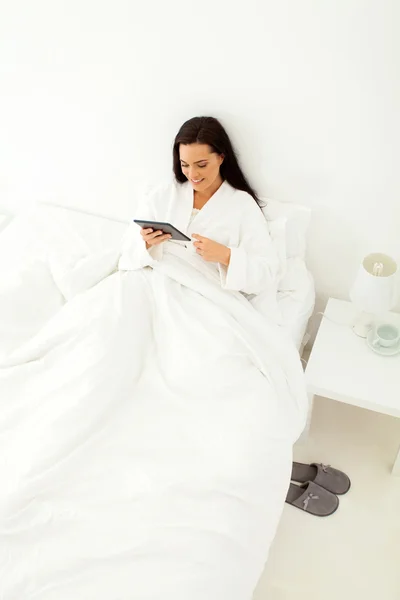 Mujer joven usando el ordenador de mesa en la cama — Foto de Stock