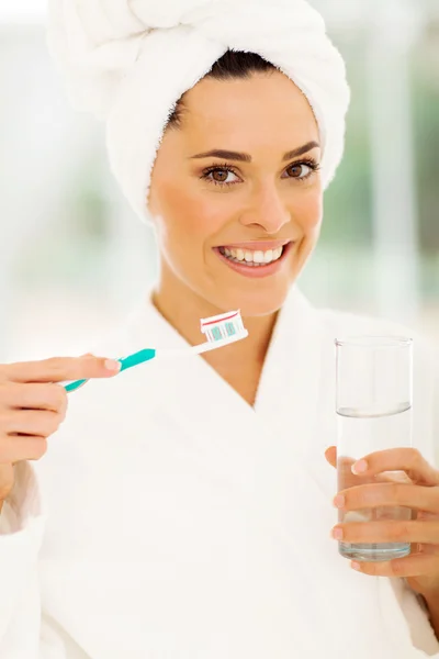 Mulher de roupão branco escovando os dentes — Fotografia de Stock