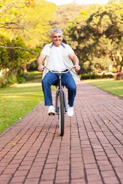 Старший мужчина на велосипеде на открытом воздухе — стоковое фото