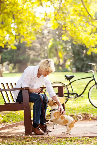 Mujer de mediana edad jugando con el perro mascota en el parque —  Fotos de Stock