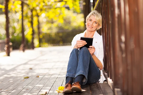 Pretty middle aged woman holding tablet computer — Stock Photo, Image