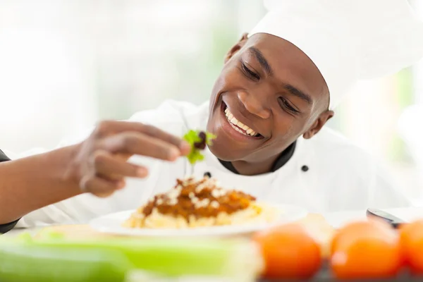 Африканський шеф-кухар прикрашає спагеті — стокове фото