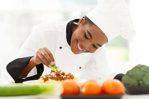 Africano femmina chef guarnire piatto di spaghetti — Foto Stock