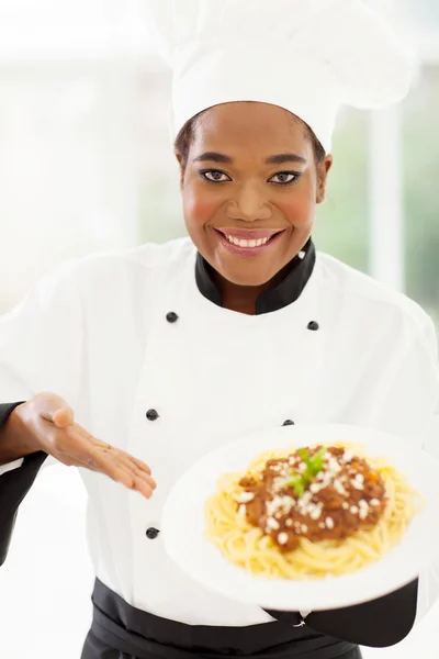 Професійний жіночий африканський шеф-кухар, що представляє макарони — стокове фото