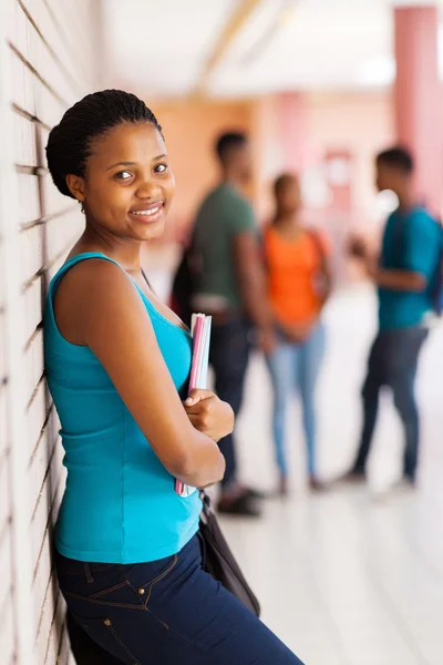 African female student leaning against a wall — Stock Photo, Image