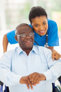 yaşlı bir Afrikalı-Amerikalı adam ve bakmakta genç caregiver