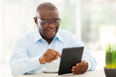üst düzey Afrikalı-Amerikalı adam evde tablet bilgisayar kullanma