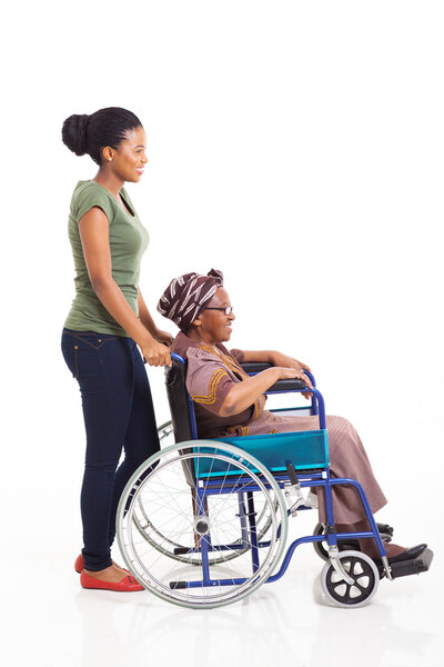 young african woman pushing grandmother on wheelchair