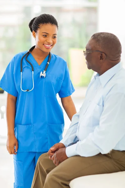 African medical doctor talking to senior man — Stock Photo, Image