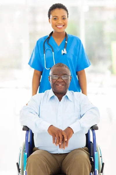Pretty african health care worker and disabled senior patient — Stock Photo, Image