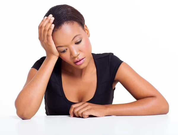 Triste femme afro-américaine assise à un bureau — Photo