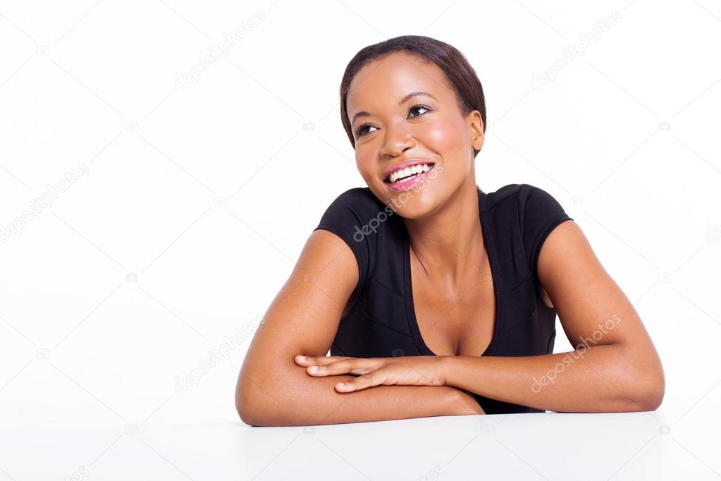 african woman sitting at a desk fantasizing
