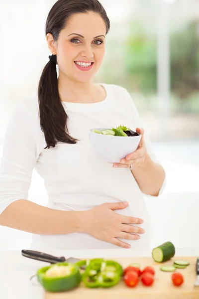 Těhotná žena držící misku salátu — Stock fotografie