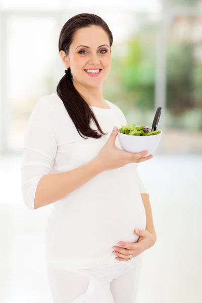 Mujer embarazada sosteniendo tazón de ensalada verde — Foto de Stock