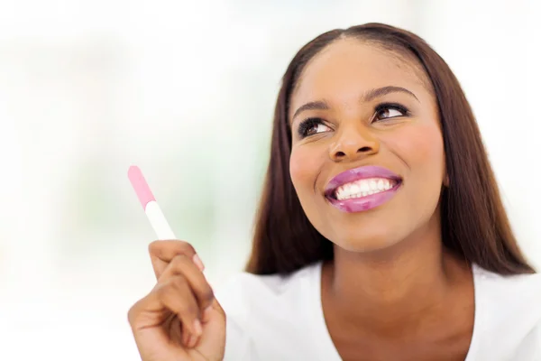 Mujer africana sosteniendo prueba de embarazo — Foto de Stock