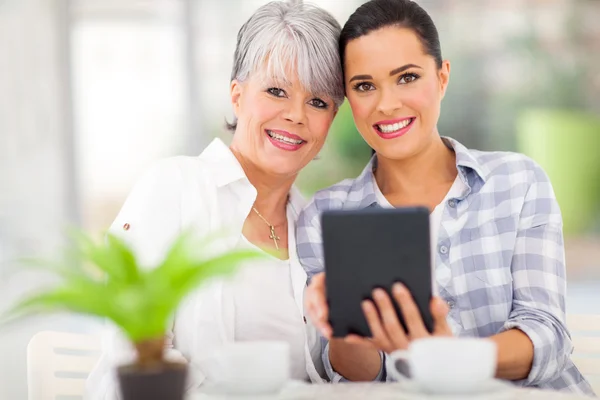 Dotter med TabletPC med henne mellersta åldern mor — Stockfoto