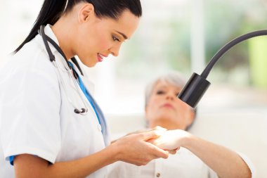 üst düzey kadının tenini inceleyerek dermatolog