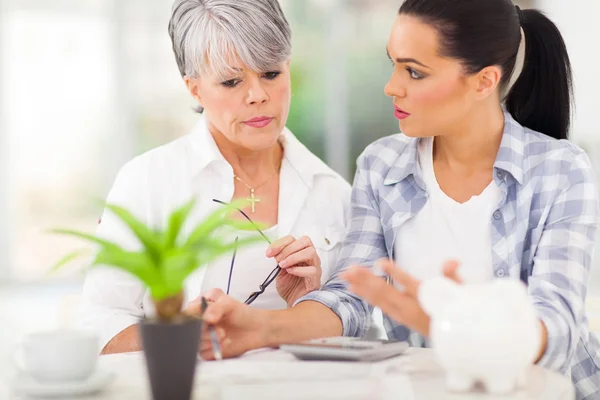 Adult daughter helping senior mother with her finances — Stock Photo, Image