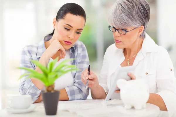Mid age mother helping daughter with her financial — Stock Photo, Image