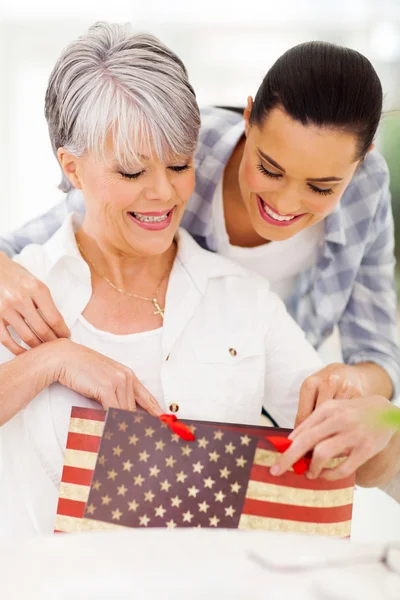 Senior woman opening present from daughter — Stock Photo, Image