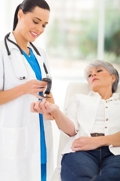 Medicinsk sjuksköterska kontrollera mitten äldre patientens puls — Stockfoto