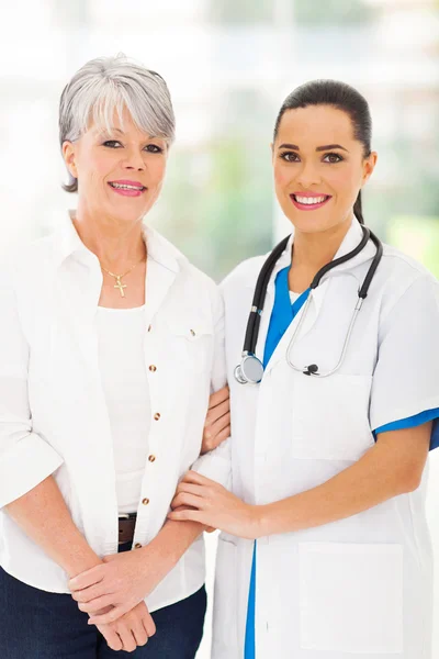 Заботливая медсестра, стоящая со старшим пациентом — стоковое фото
