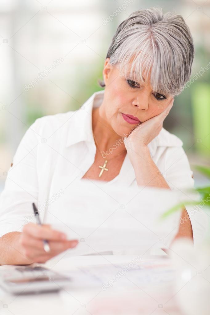 stressed senior woman paying her bills