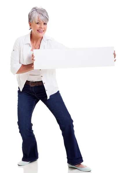 Mujer madura divertida presentando banner — Foto de Stock