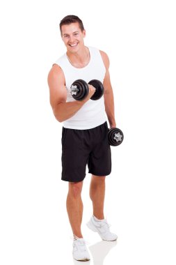 Dambıllarla egzersiz yapan genç adam.