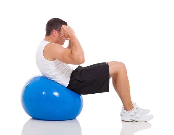 Jeune homme faisant des exercices sur la balle de gymnase — Photo