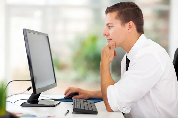 Молодой бизнесмен смотрит на экран компьютера — стоковое фото