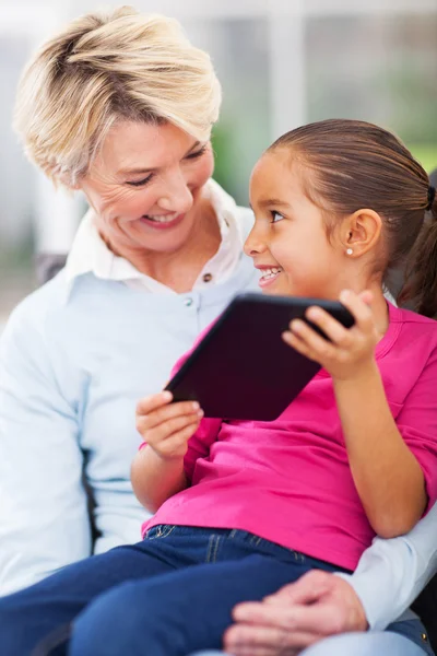 Kleines Mädchen zeigt ihrer Oma Tablet-Computer — Stockfoto