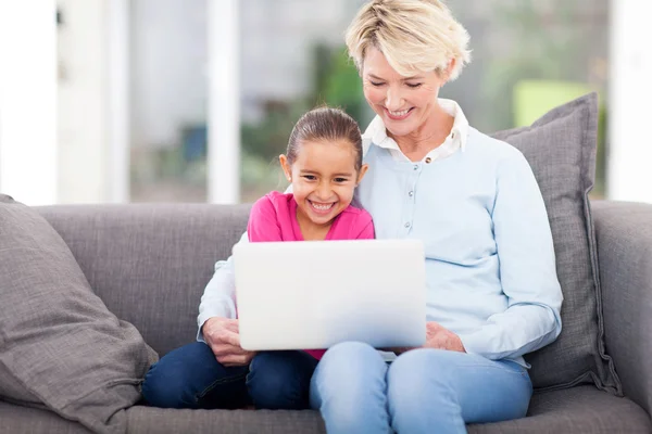 Klein meisje en grootmoeder met behulp van een laptop — Stockfoto