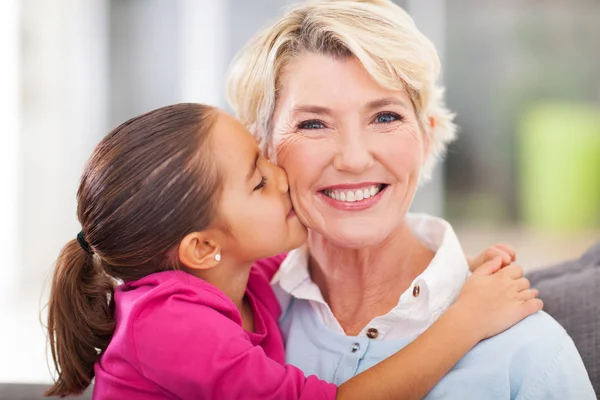 Schattig kleindochter kussen van haar grootmoeder — Stockfoto