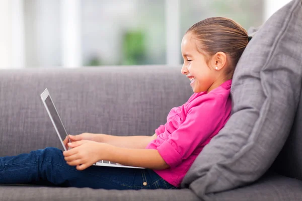 Little girl using laptop on sofa — Stock Photo, Image