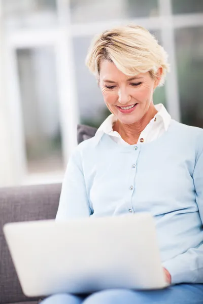 Mulher de meia idade usando computador portátil — Fotografia de Stock