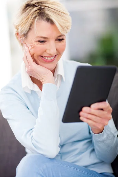 Zralá žena s knihou v tabletovém počítači — Stock fotografie