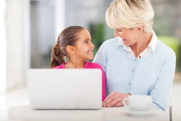 Klein meisje en oma met behulp van laptop — Stockfoto