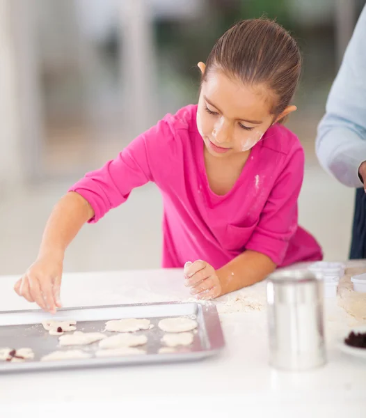 Little girl baking cookies with parent — Stock Photo, Image