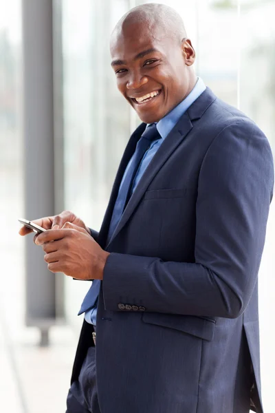 Afrikanischer amerikanischer Geschäftsmann liest E-Mail auf Smartphone — Stockfoto