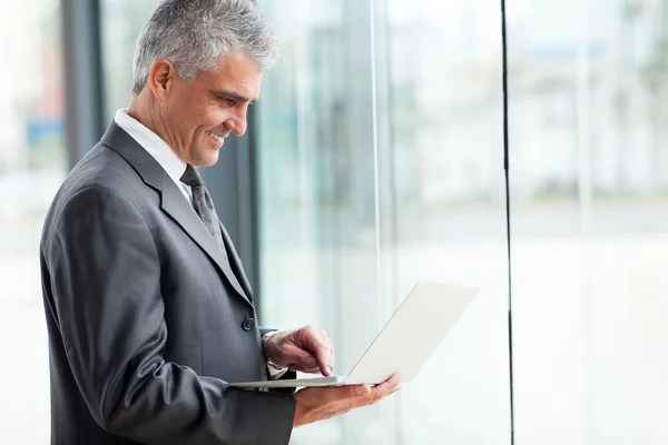 Senior businessman working on laptop — Stock Photo, Image