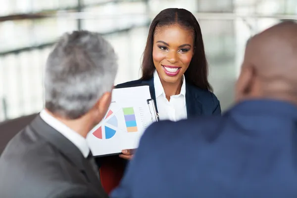 Jovem empresária africana explicando gráfico para equipe de negócios — Fotografia de Stock